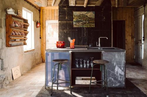 eine Küche mit einem Waschbecken und Stühlen in einem Zimmer in der Unterkunft Projektraum Obst und Sterne 
