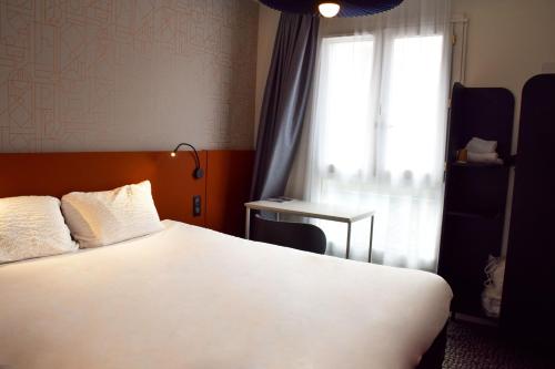 a hotel room with a bed and a window at ibis Rodez Centre in Rodez