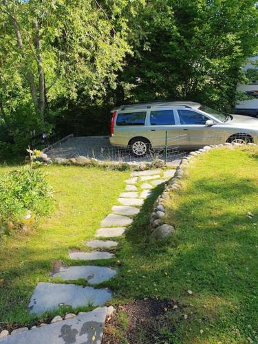 a suv parked in a yard with a stone path at Stugan in Stockholm
