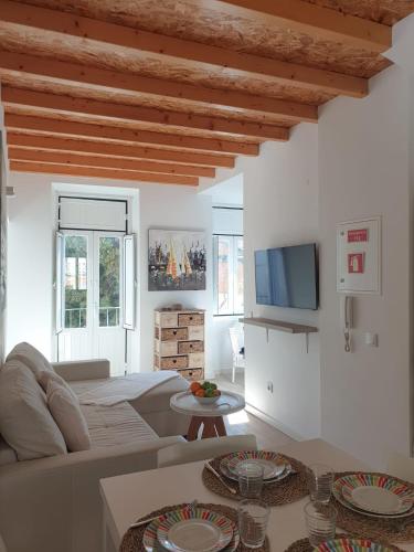 a white living room with a couch and a table at Casa Roméo à 3 min de la plage in Sesimbra