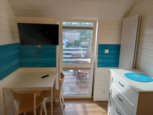 Kleines Zimmer mit einem Schreibtisch und einer Glasschiebetür in der Unterkunft Morski 1 in Stegna