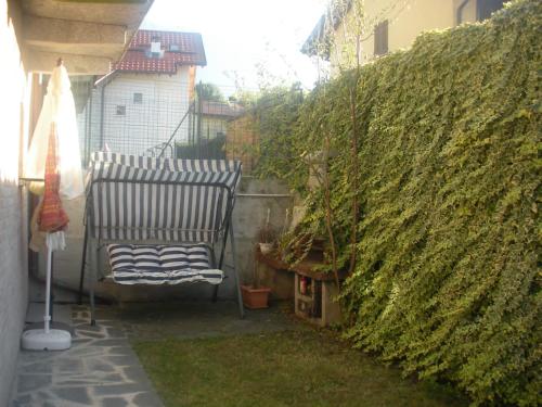 een stoel op een patio naast een heg bij CASA ARCOBALENO in Colico