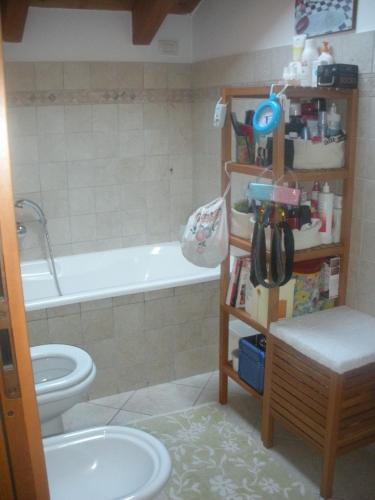 een badkamer met een bad, een toilet en een wastafel bij CASA ARCOBALENO in Colico