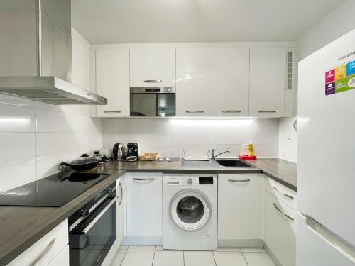 a white kitchen with a washing machine in it at Maison de Charme - parking gratuit près de Paris & métro in Villejuif