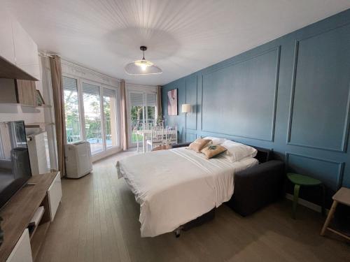 um quarto com uma cama e uma parede azul em Maison de Charme - parking gratuit près de Paris & métro em Villejuif