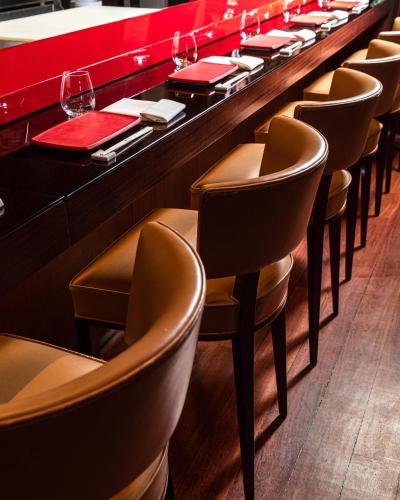 a row of chairs at a bar in a restaurant at Hôtel Le Royal Monceau Raffles Paris in Paris