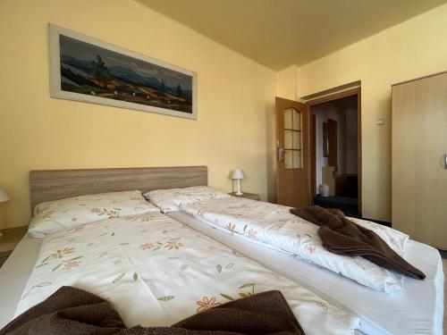 a bed in a bedroom with a picture on the wall at Penzion Pod Ždánovem in Nezdice