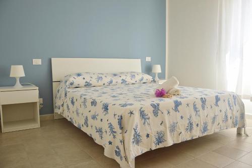 a bedroom with a bed with a blue and white comforter at B&B Campitur in Campomarino