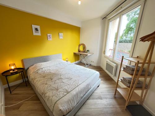 - une chambre avec un lit et un mur jaune dans l'établissement Le Delos - Centre ville - Parking - 2 pers, au Mans