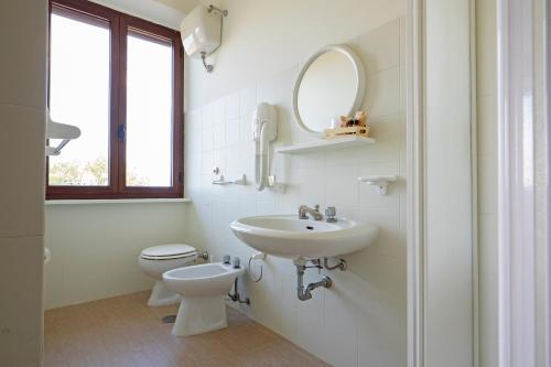 bagno con lavandino, servizi igienici e specchio di Tenuta Di Corbara a Corbara