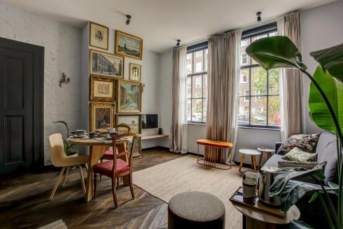 a living room with a table and chairs at Canal House with Garden in Amsterdam