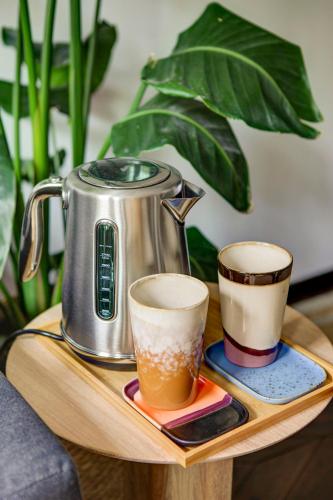 a tea kettle and two cups on a wooden tray at Canal House with Garden in Amsterdam