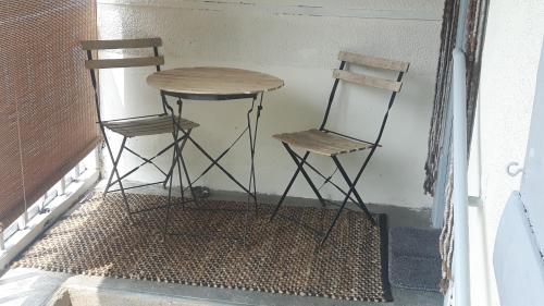 two chairs and a table and a table and two stools at Charmante maison Lotoise in Bretenoux
