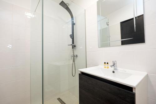 Un baño con lavabo y ducha en Torraltinha Sunset Apartment, en Lagos