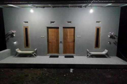 a building with two benches in front of it at SPOT ON 92699 Irish Irish Homestay in Banyuwangi