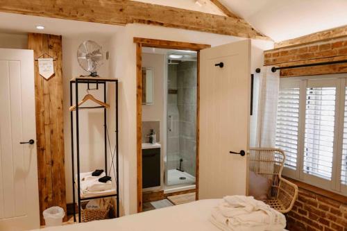 um quarto com uma casa de banho com um chuveiro e um lavatório em The Threshing Barn - relaxing countryside spa break em Pentney