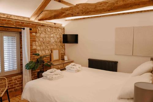 a bedroom with two beds with towels on them at The Threshing Barn - relaxing countryside spa break in Pentney