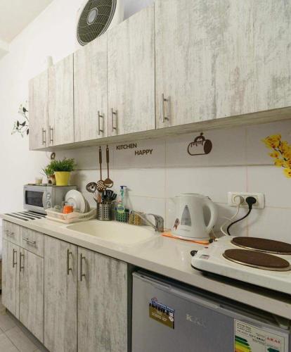 a kitchen with white cabinets and a counter top at סטודיו חדשה ליד הים רחוב בוגרשוב in Tel Aviv