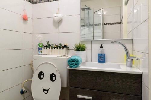 a bathroom with a toilet with a face drawn on it at סטודיו חדשה ליד הים רחוב בוגרשוב in Tel Aviv