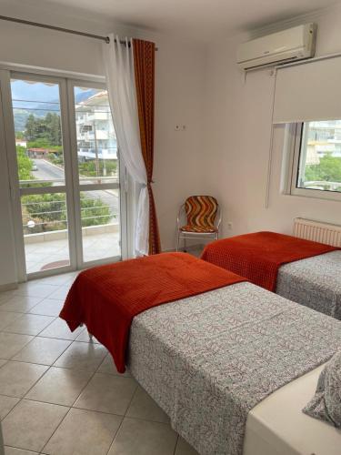 Habitación de hotel con 2 camas y ventana en Pearl of Paralia Akrata en Akrata