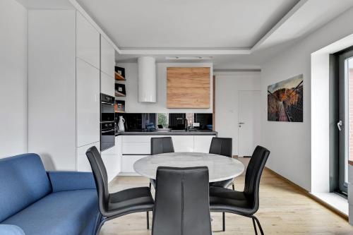 a kitchen and dining room with a table and chairs at GRANO APARTMENTS Gdańsk Old Town SPA & Wellness - GRANO APARTMENTS Gdańsk Residence SPA & Wellness in Gdańsk