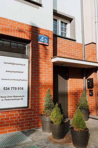 a brick building with potted plants in front of it at Noclegi Przy Stacji in Nowy Dwór Mazowiecki