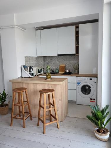 a kitchen with a counter and two stools at Mara Apartment in Năvodari