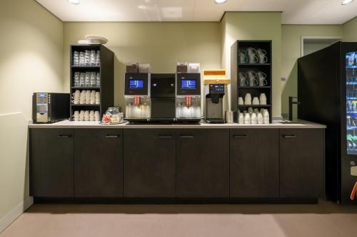 a coffee shop with a counter with aasteryasteryasteryasteryasteryasteryasteryastery at Stayokay Hostel Utrecht Centrum in Utrecht