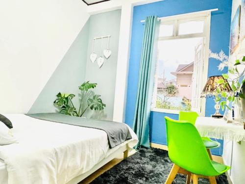 - une chambre avec un lit et une chaise verte dans l'établissement TAM GIAC MẠCH HOUSE, à Đà Lạt