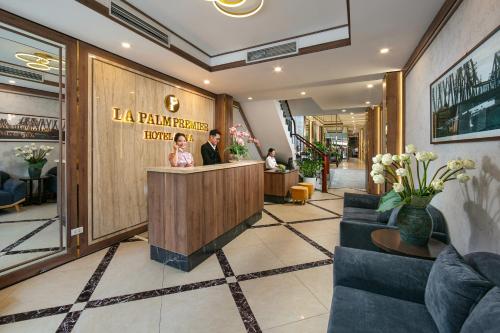 a lobby with a man and a woman at a counter at Hanoi La Palm Premier Hotel & Spa in Hanoi