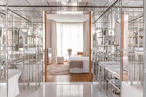 a room with many glass shelves with a bed at Hôtel Le Royal Monceau Raffles Paris in Paris