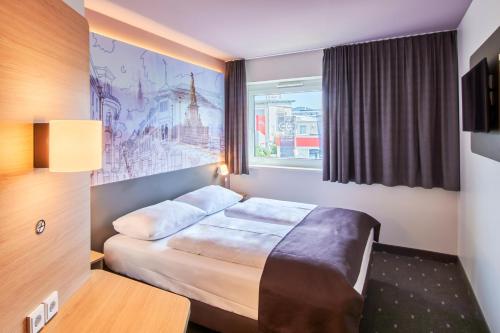 een hotelkamer met een bed en een raam bij B&B Hotel Heidelberg in Heidelberg
