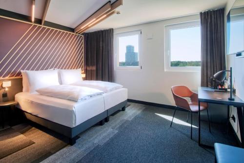 una camera d'albergo con letto e scrivania di B&B Hotel Frankfurt-Airport a Francoforte sul Meno