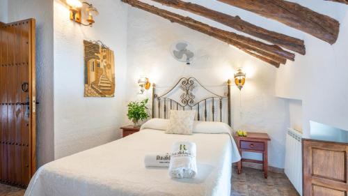 ein Schlafzimmer mit einem weißen Bett in einem Zimmer in der Unterkunft Cortijo Alzamigaja Archidona by Ruralidays in Archidona