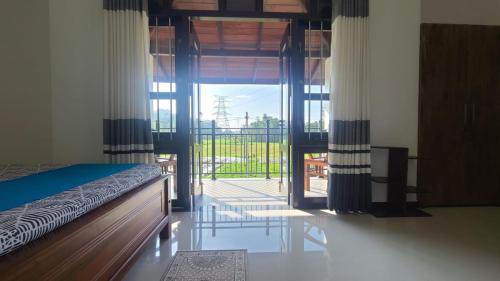 - une chambre avec un lit et une grande porte en verre dans l'établissement Villa Crimson Bay, à Unawatuna