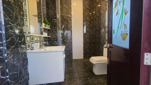 La salle de bains est pourvue d'un lavabo blanc et de toilettes. dans l'établissement Villa Crimson Bay, à Unawatuna