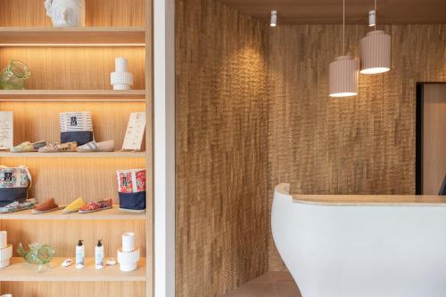 La salle de bains est pourvue de toilettes blanches et d'un mur en bois. dans l'établissement Residence Ibaia, à Hendaye
