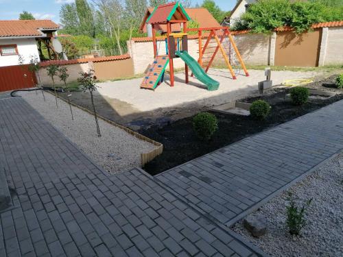 a playground with a slide in a backyard at Horgász-Lak vendégház in Nagybaracska