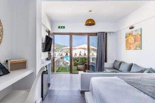 a hotel room with a bed and a living room at Skopelos Holidays Hotel & Spa in Skopelos Town