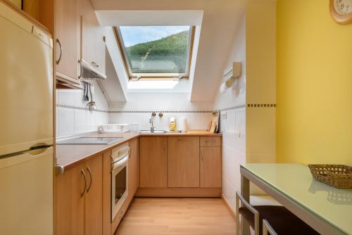 a small kitchen with a sink and a window at Atico la Espata Villanua in Villanúa