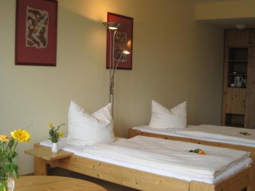 2 camas en una habitación con sábanas blancas en Doppelzimmer 13 Gästehaus Mühlenstein en Bad Sülze