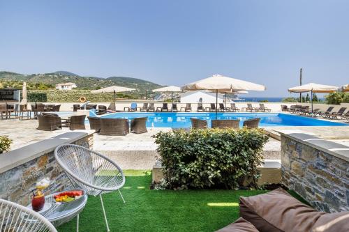ein Resort mit einem Pool, einem Tisch und Stühlen in der Unterkunft Skopelos Holidays Hotel & Spa in Skopelos