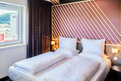 um quarto com 2 camas e uma janela em B&B Hotel Heidelberg em Heidelberg
