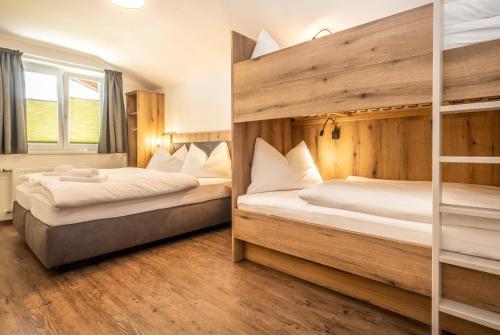 two beds in a room with two bunk beds at Alpha Apartments in Schwarzach im Pongau