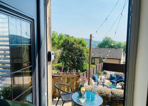 a patio with a table and chairs on a balcony at Helter Skelter Matlock in Matlock