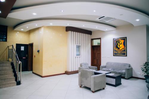 a lobby with chairs and a table and stairs at Gold Crest Hotel in Mwanza