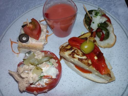 a plate of food with a sandwich and a drink at Cleopatra Spa Hotel in Lloret de Mar