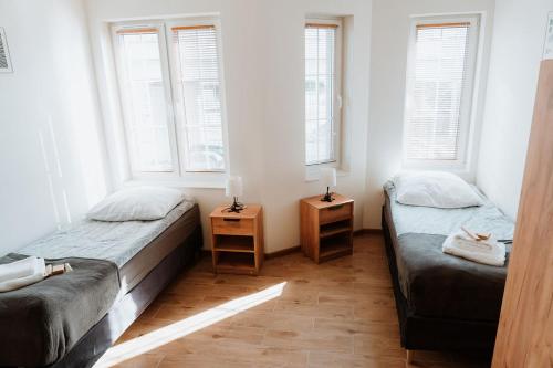 two beds in a room with two windows at Noclegi Przy Stacji in Nowy Dwór Mazowiecki