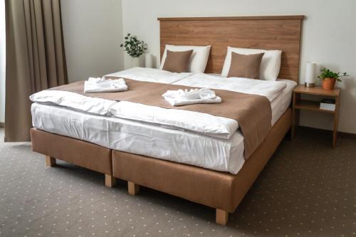 a bedroom with a large bed with two towels on it at Penzion Golf Luby in Luby