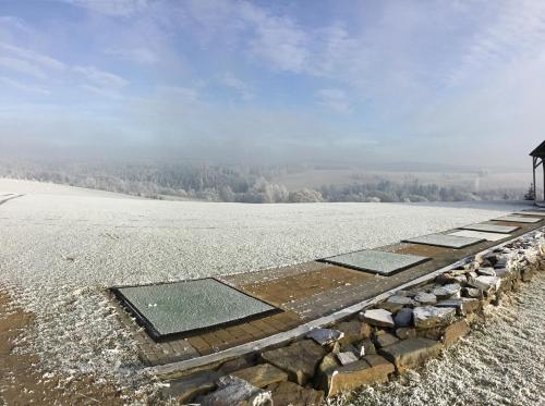 a snow covered field with a walkway in the middle at Penzion Golf Luby in Luby